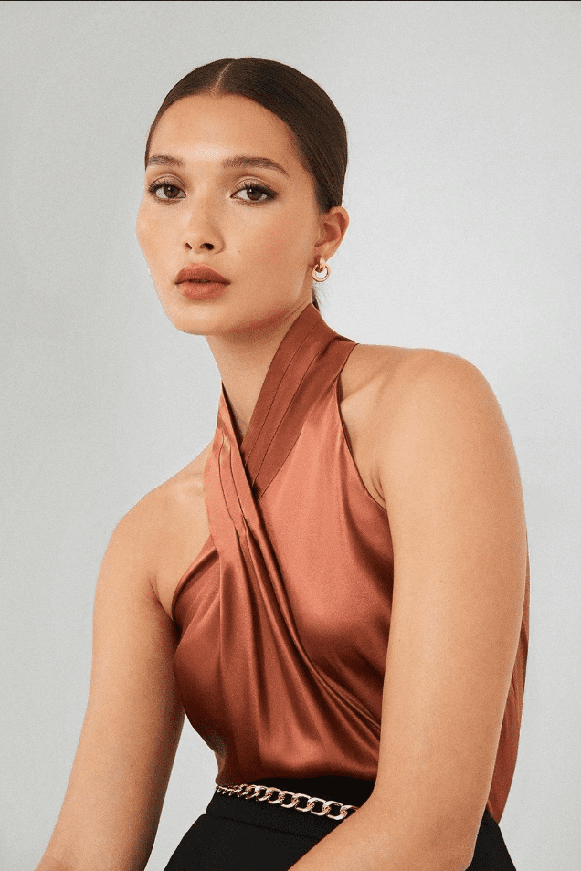 A woman wearing a burnt orange halter top