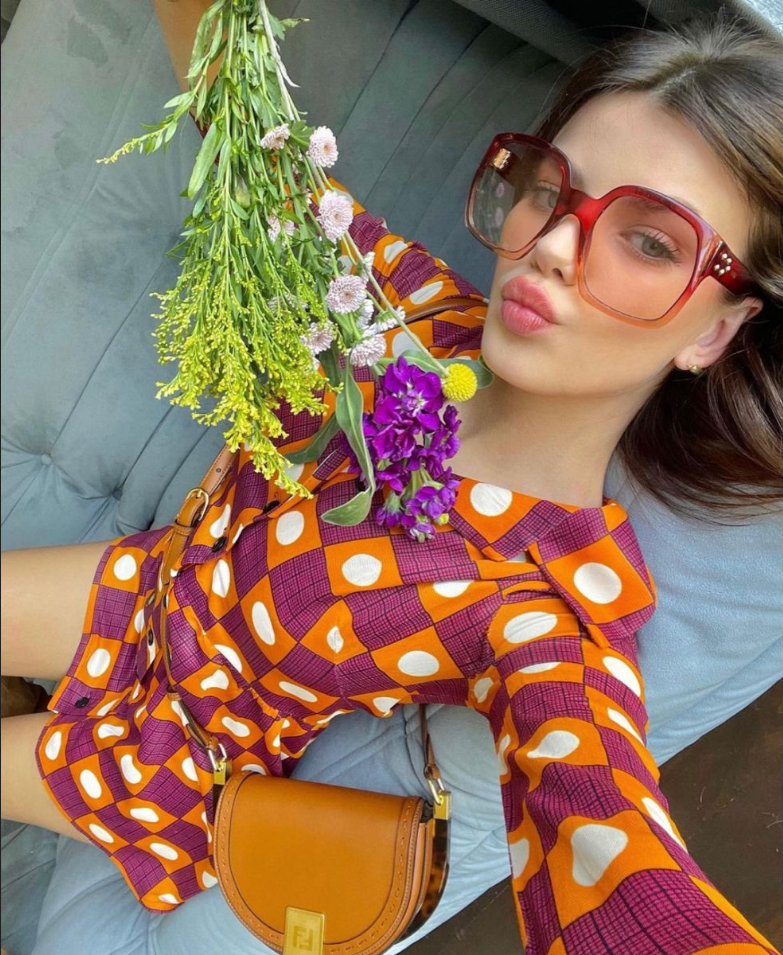 A woman wearing a colorful print dress