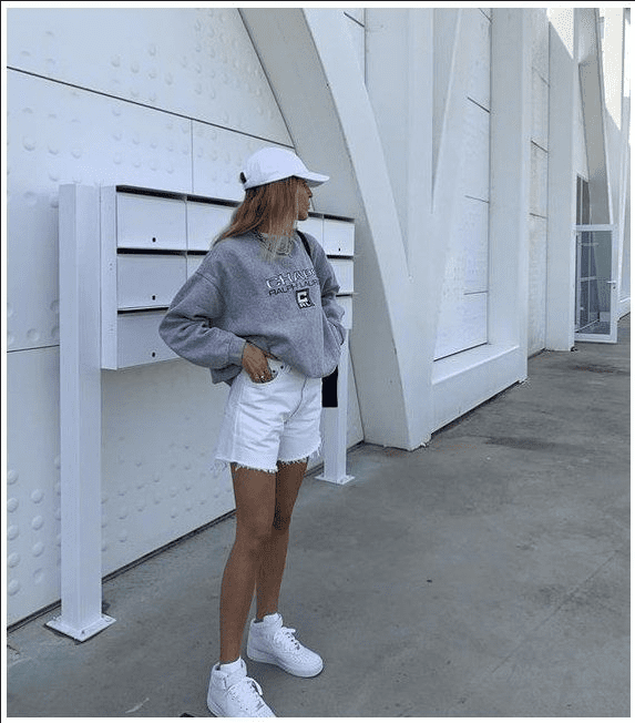 A woman wearing white mom shorts
